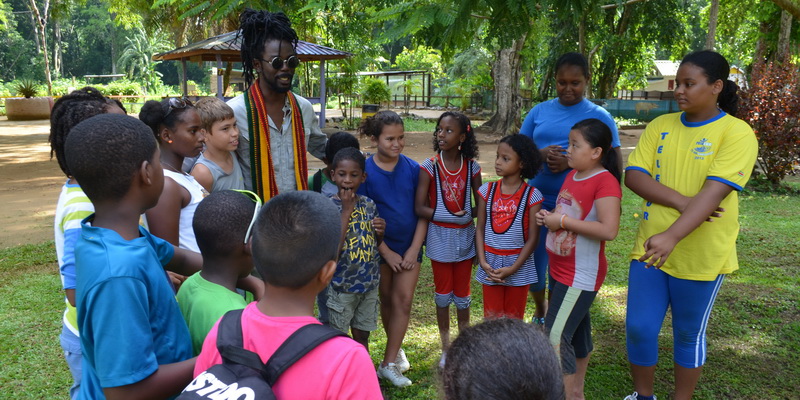 Kenny B spreads the “Krape? Nee!” message with local children at the zoo (© WWF-Guianas)